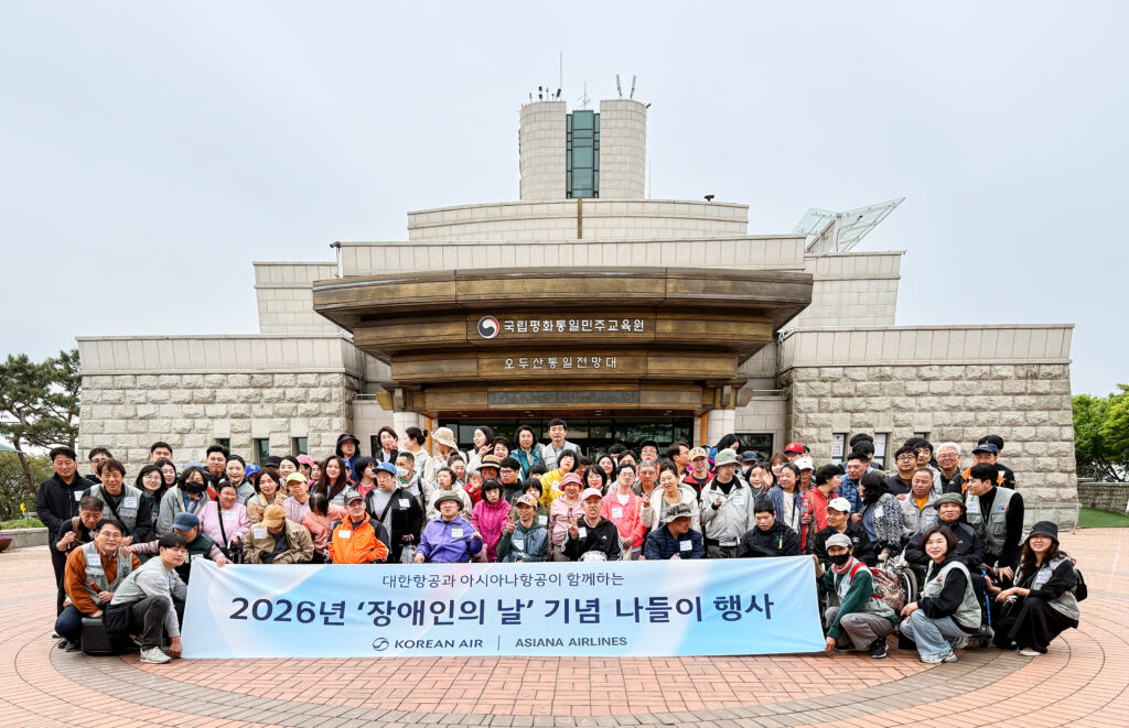대한항공과 아시아나항공 사내 봉사단 소속 임직원들이 22일 경기 파주시 오두산 통일전망대에서 장애인 문화체험 활동을 지원하며 기념사진을 촬영하고 있다